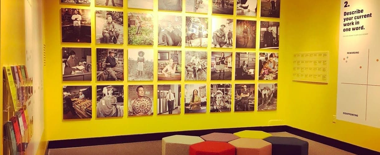 Yellow room with interactive sticker exhibit at Baltimore Museum of Industry